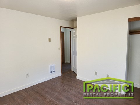 a living room with white walls and a wooden floor