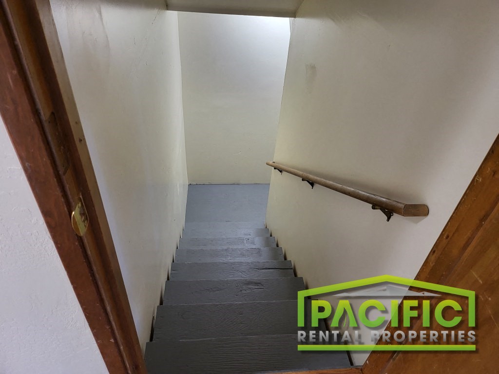 a stairwell in a room with a rail and a white wall