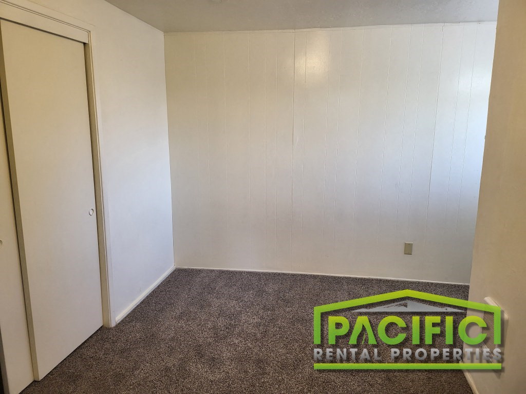 a room with a carpet and a door to a closet