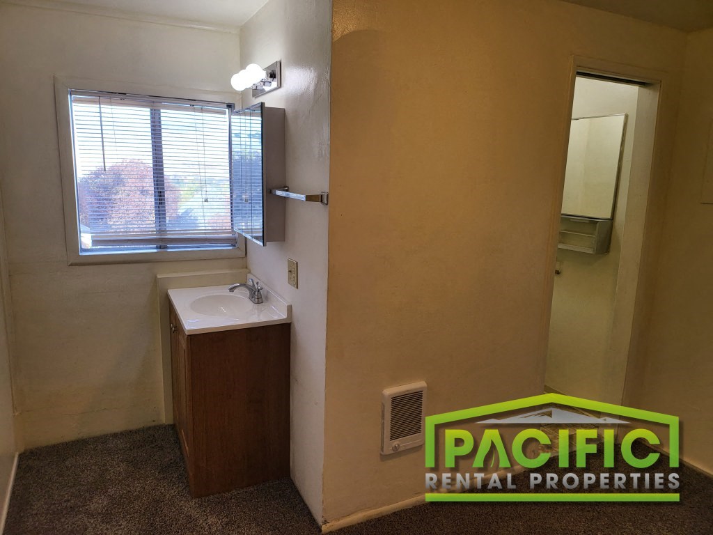 a small bathroom with a sink and a window