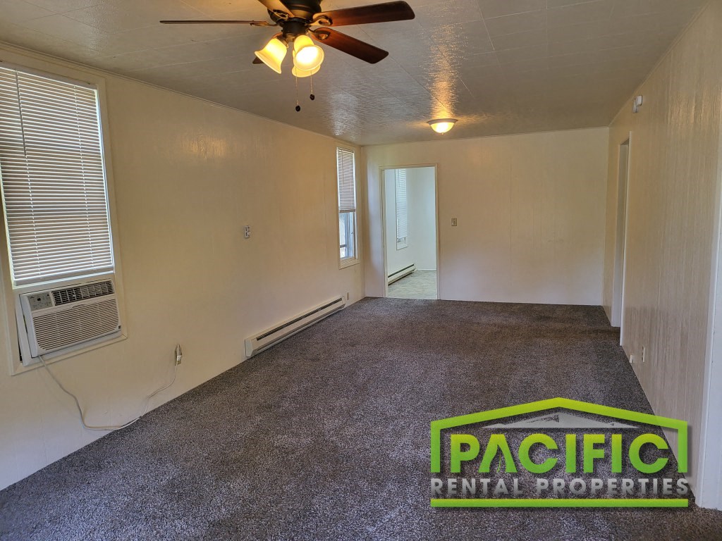 a empty living room with a ceiling fan