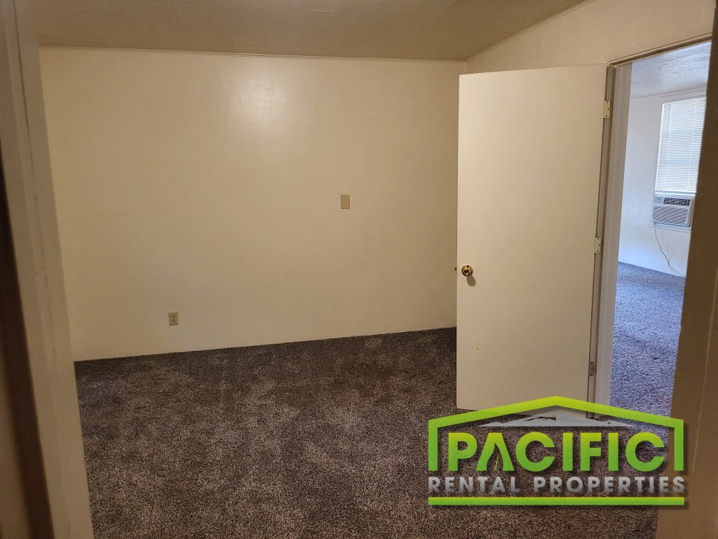 an empty room with a carpeted floor and a sign for pacific dental properties