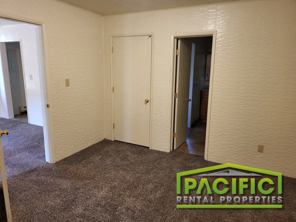 a bedroom with a carpeted floor and a door to a closet