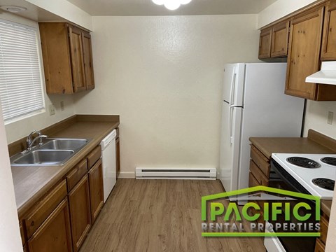 a kitchen with wooden cabinets and a sink and a refrigerator