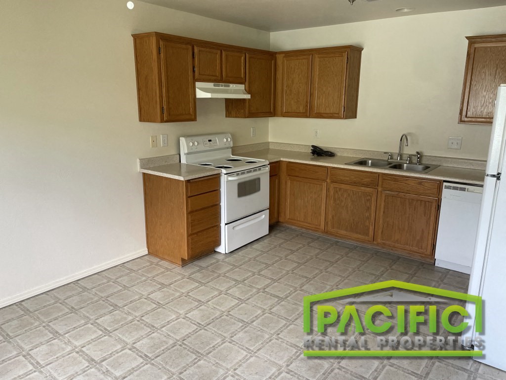 an empty kitchen with a stove and a sink