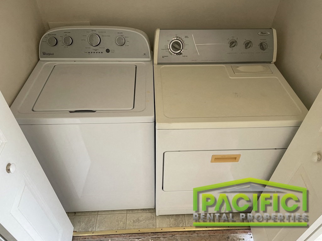 two washers and a dryer in a laundry room