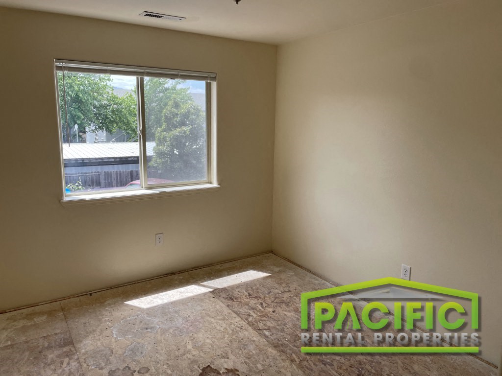 an empty room with a window and a tiled floor