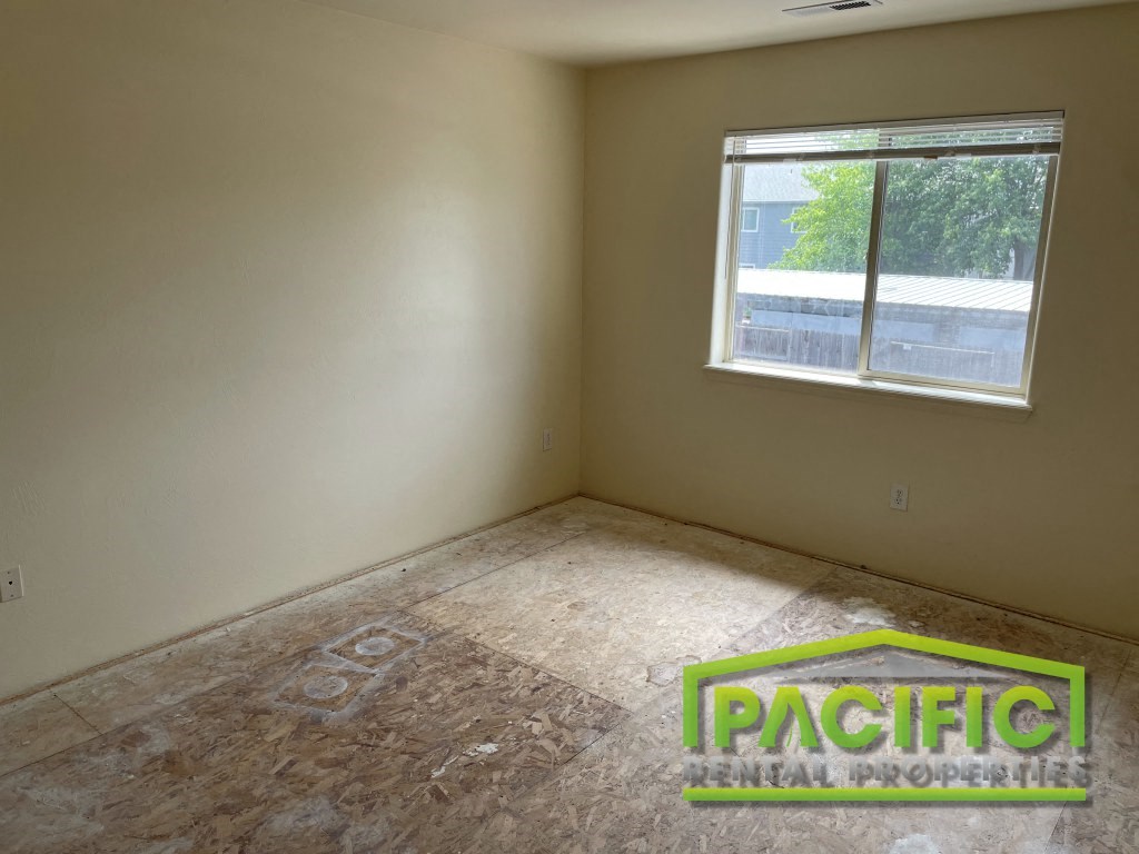 the interior of a room with a wooden floor and a window
