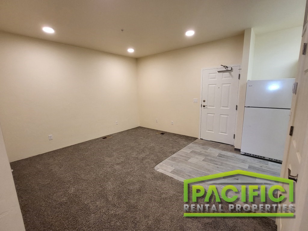 an empty room with a refrigerator and a door