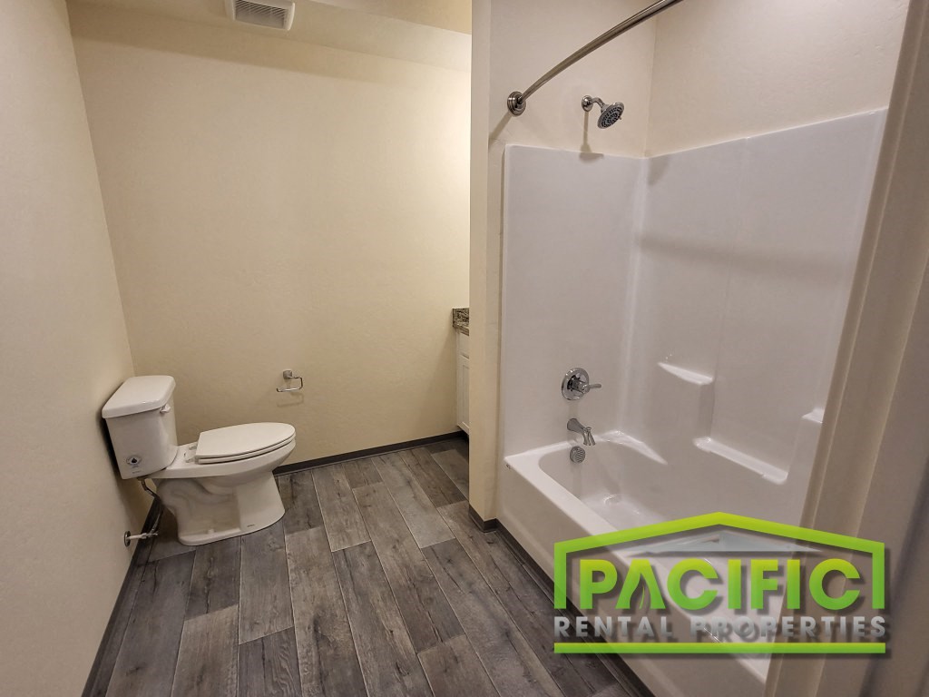 a bathroom with a toilet and a tub and a shower