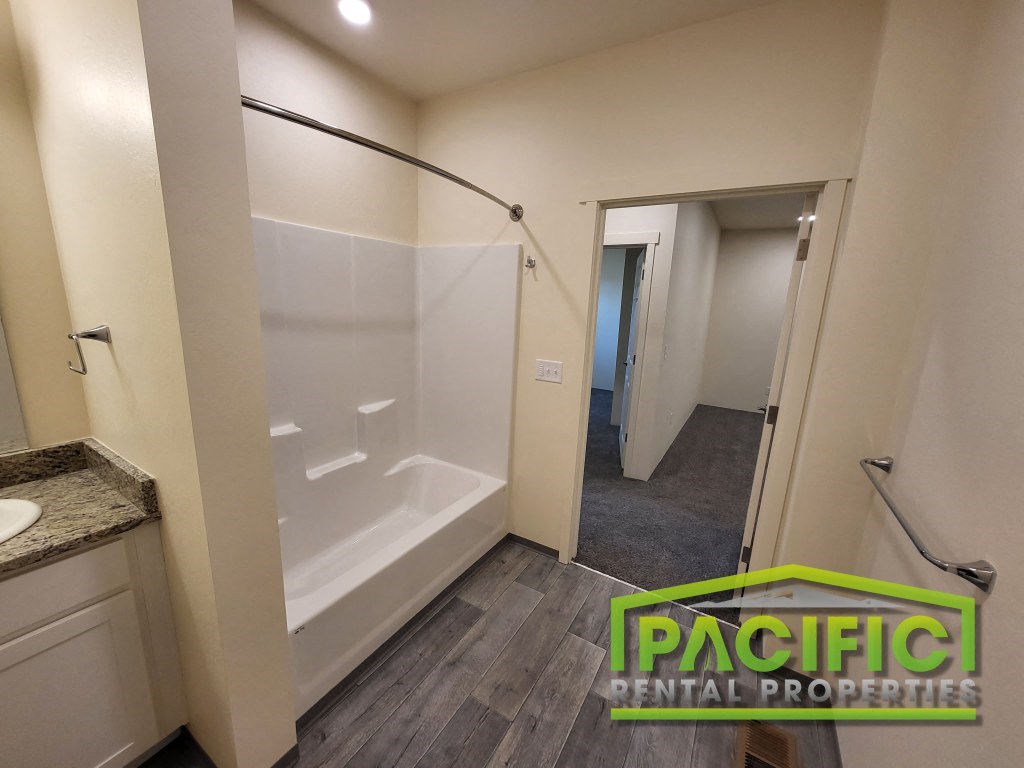 a bathroom with a shower and a sink and a mirror