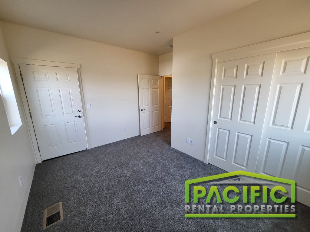 a bedroom with two closets and a carpeted floor