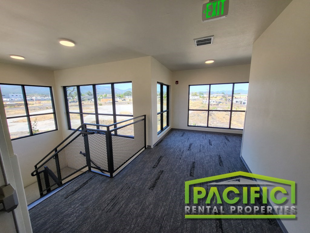 an empty living room in a building with windows and stairs
