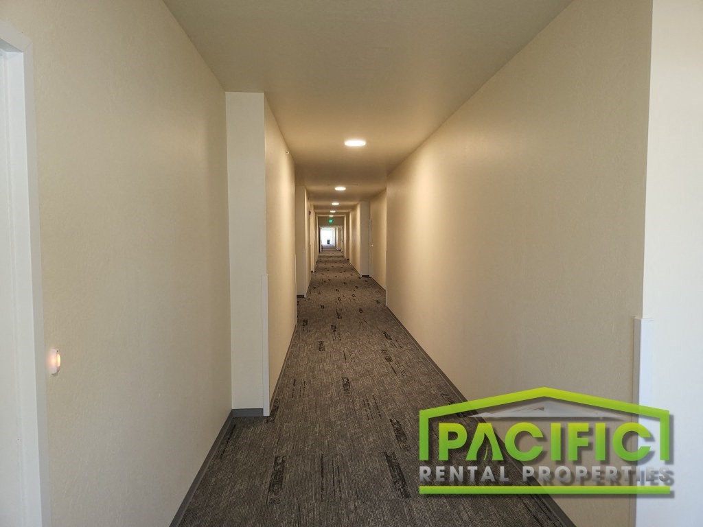 a long hallway with white walls and a carpeted floor