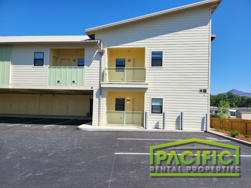 a new apartment building with yellow and white siding and a driveway