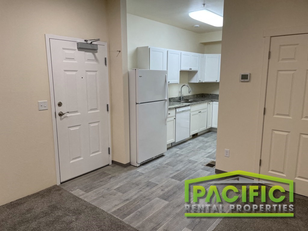 a renovated kitchen with white cabinets and a refrigerator