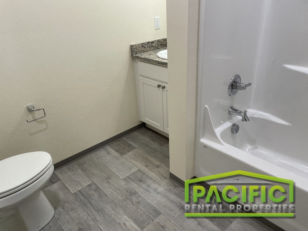 a bathroom with a toilet and a tub and a sink