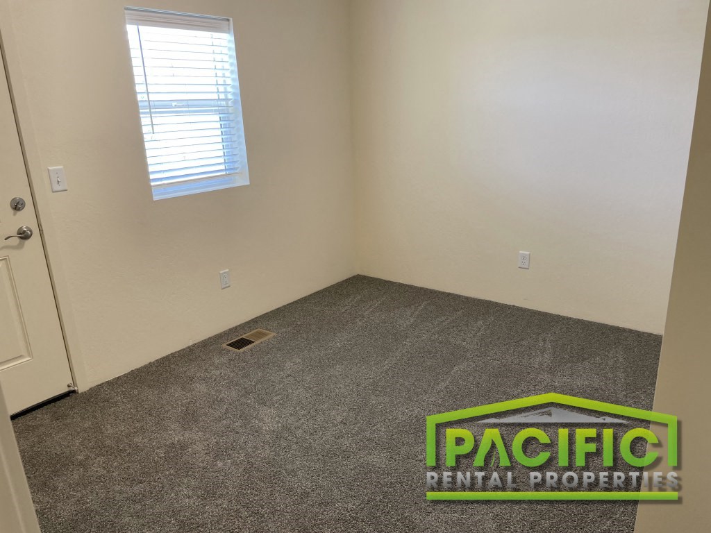 a room with carpet and a door and a window