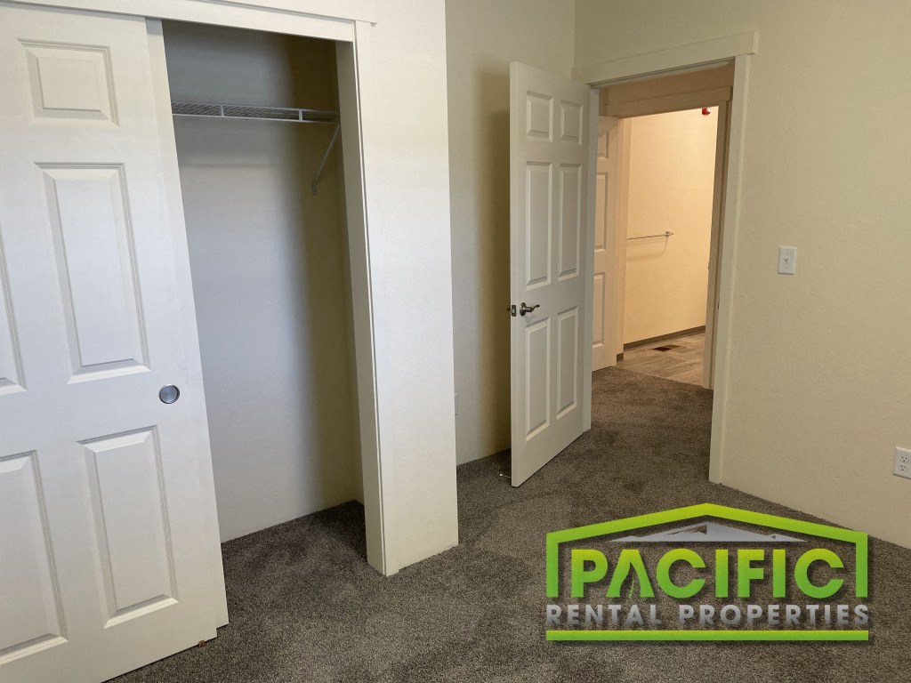 a bedroom with a closet and an open door and a carpeted floor