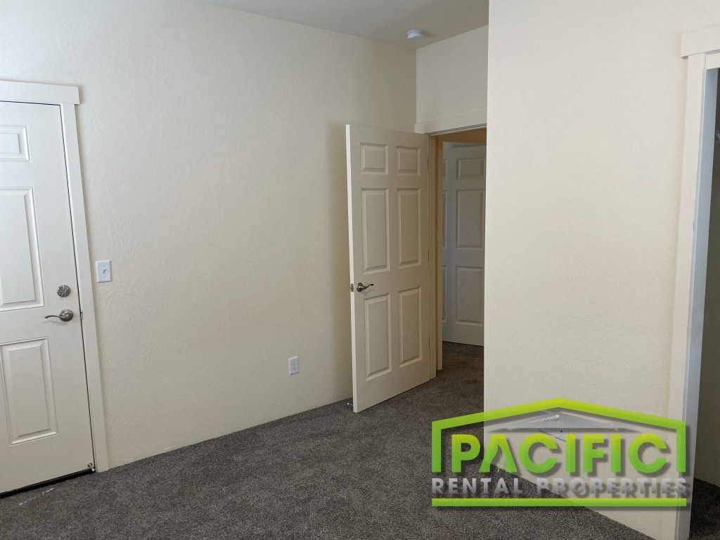 a bedroom with a closet and a door and a carpeted floor