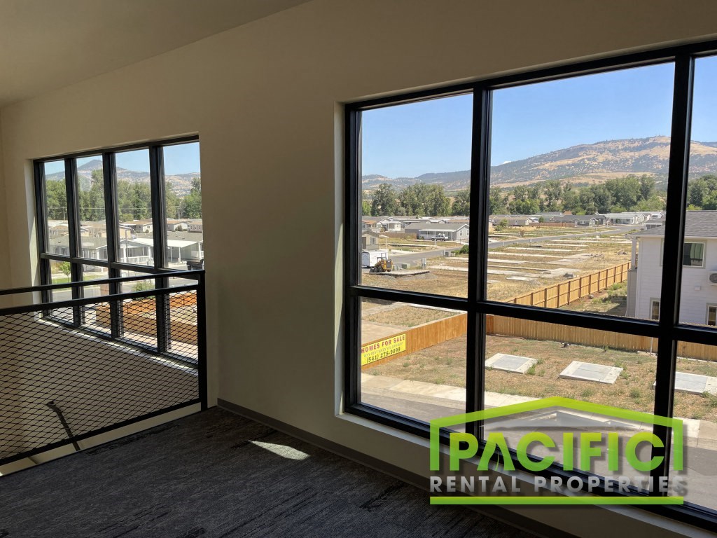 a living room with large windows and a view of a construction site