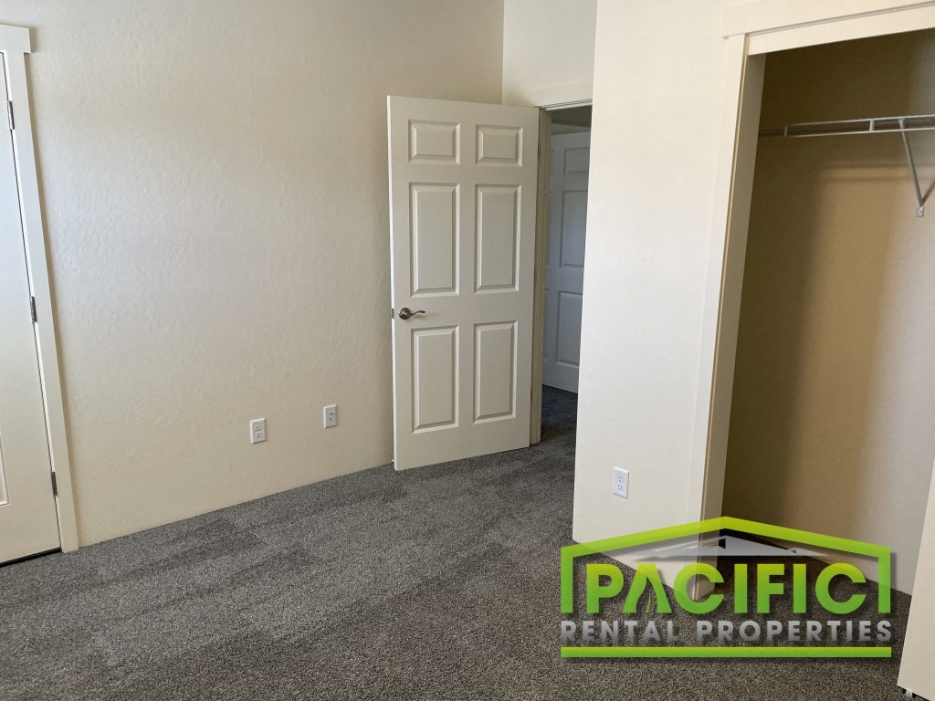 a room with a closet and an open door and a carpeted floor