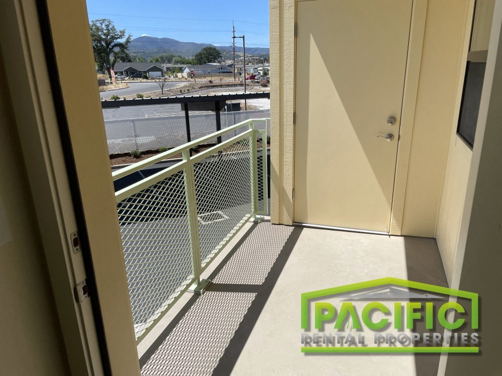 a balcony with a metal railing and a view of the street