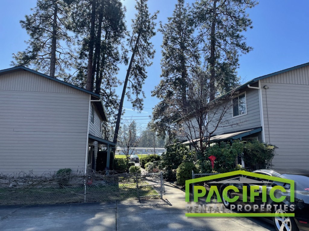 a house with tall trees next to it