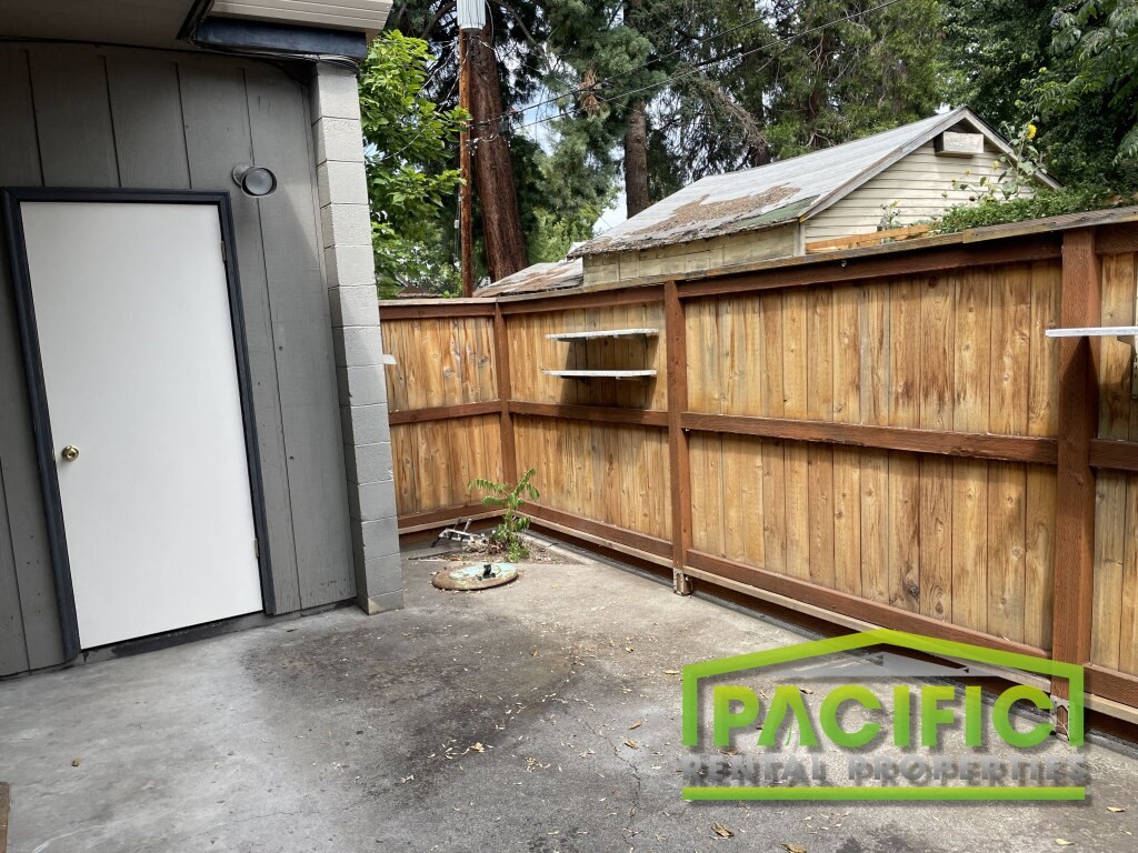 a backyard with a wooden fence and a garage door