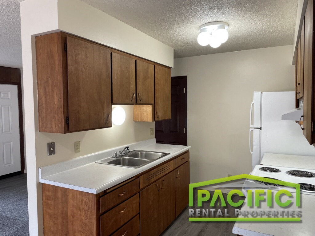 a kitchen with white appliances and wooden cabinets