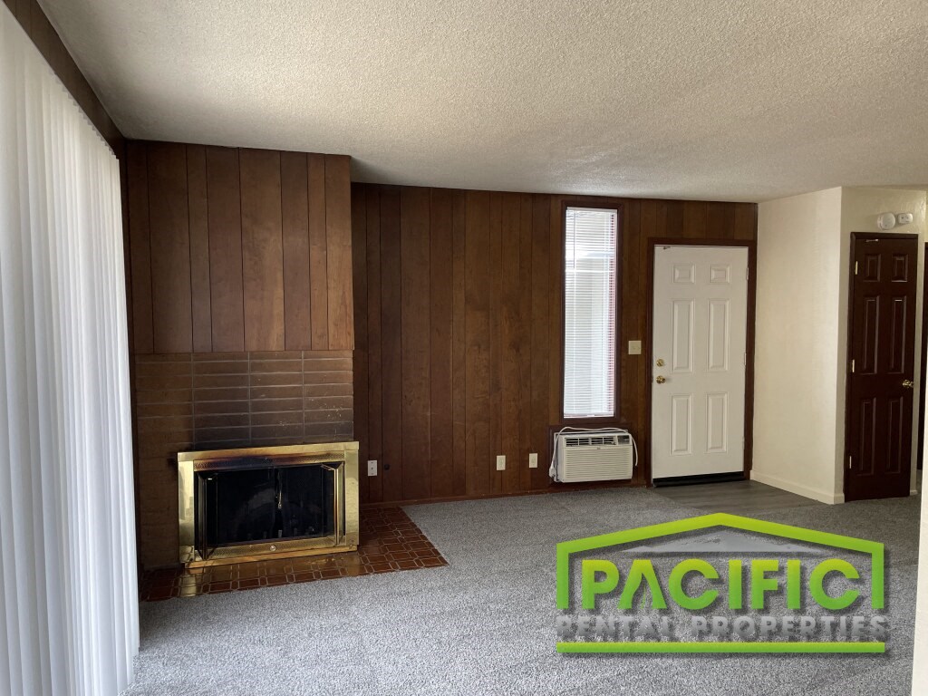 a living room with a fireplace and a carpet on the floor