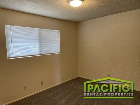 a living room with a window and a pacific rental properties logo