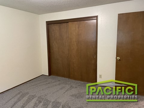 a bedroom with a wooden closet and a carpeted floor