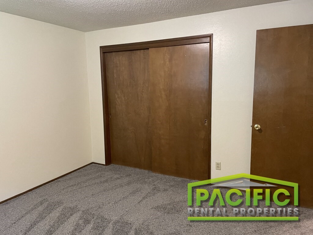 a bedroom with a wooden closet and a carpeted floor