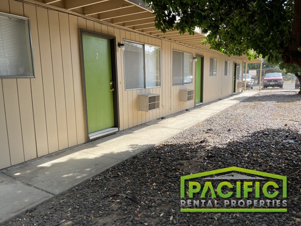 the exterior of a building with a green door and a sidewalk
