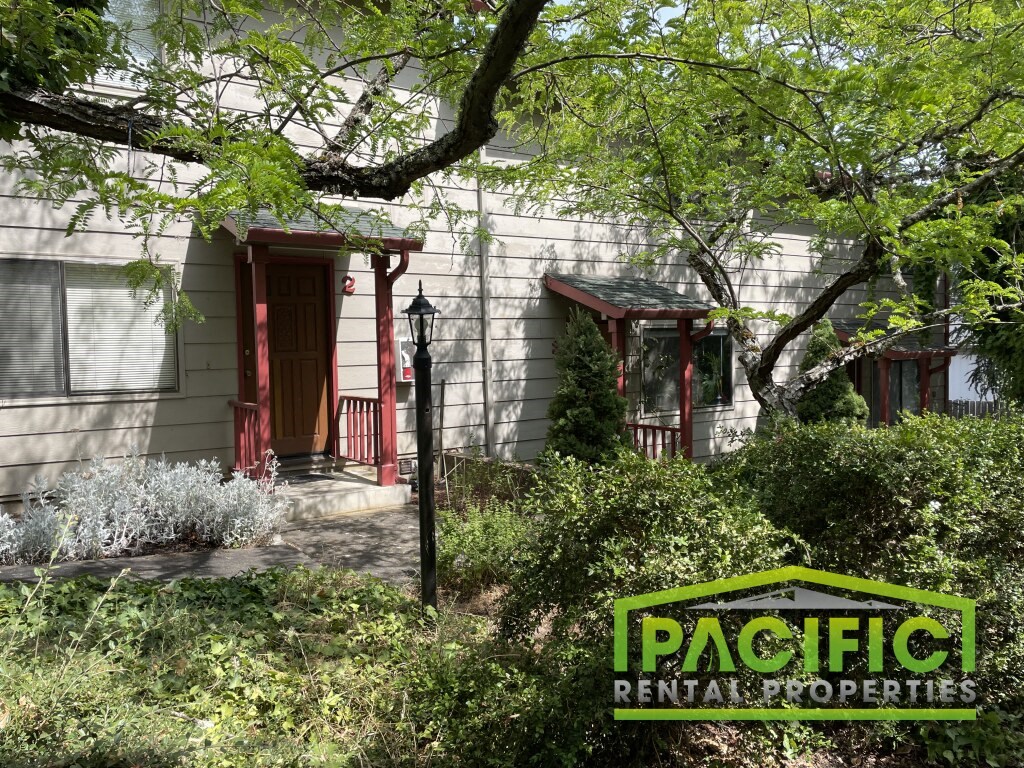 a house with a red door and a patio rental properties sign