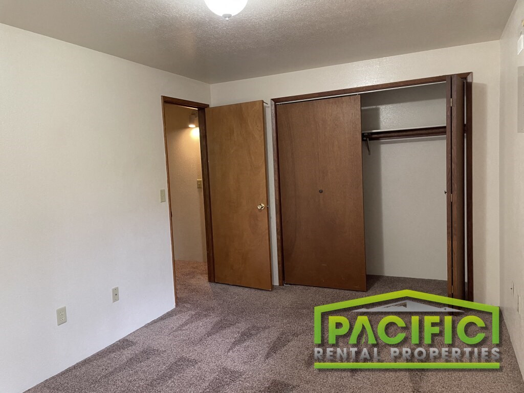 a living room with a carpeted floor and two closet doors