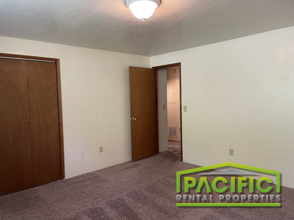 a bedroom with a carpeted floor and a door to a closet