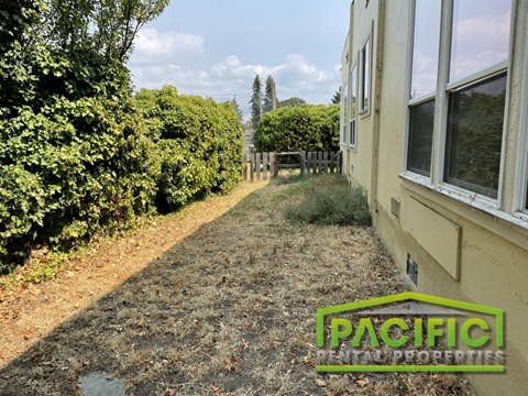 a yard with a dirt path next to a house
