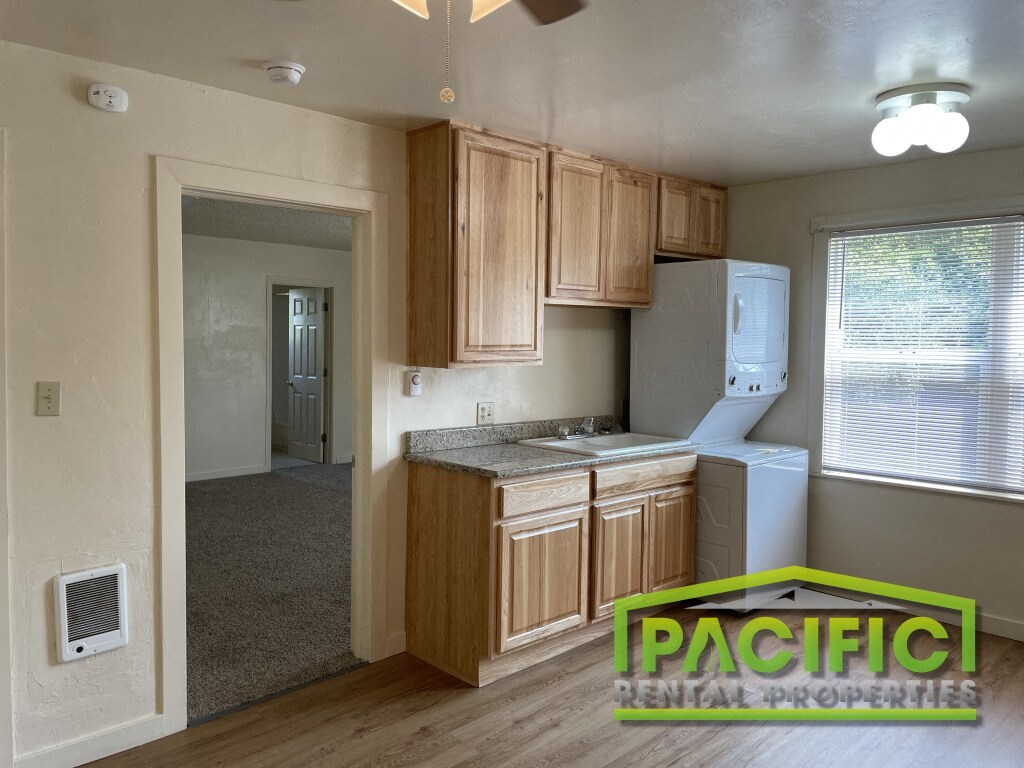 a small kitchen with wooden cabinets and a white refrigerator