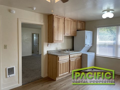 a small kitchen with wooden cabinets and a white refrigerator