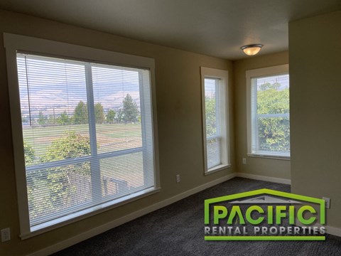 a living room with large windows overlooking a field