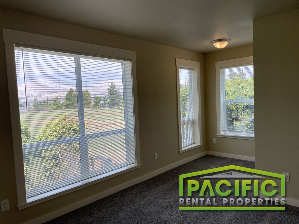 a living room with large windows overlooking a field