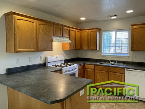 A kitchen with wooden cabinets and a stove top oven.