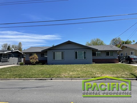 A house with a sign that says Pacific in front of it.