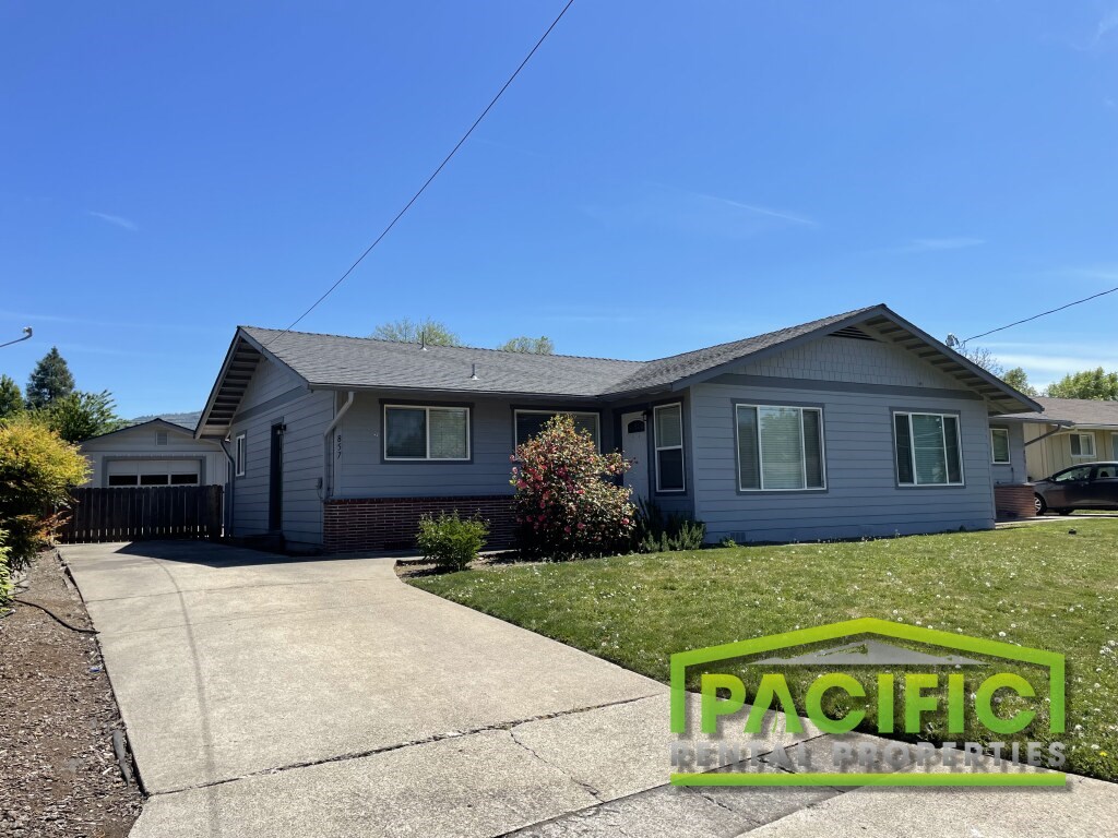 A house with a driveway in front of it and a sign that says Pacific Realty Properties.
