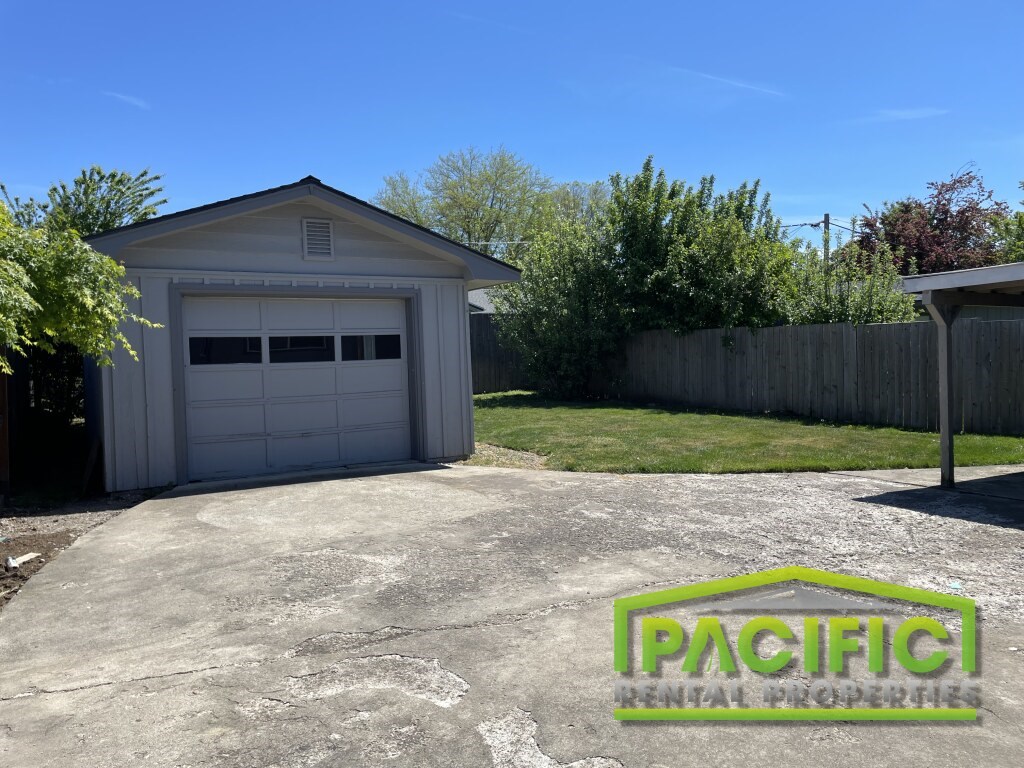 A garage with a Pacific Rental Properties logo on the ground.