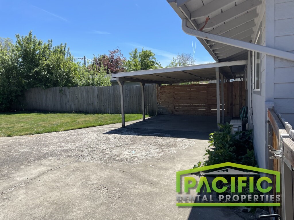 A white house with a covered patio area is for sale.