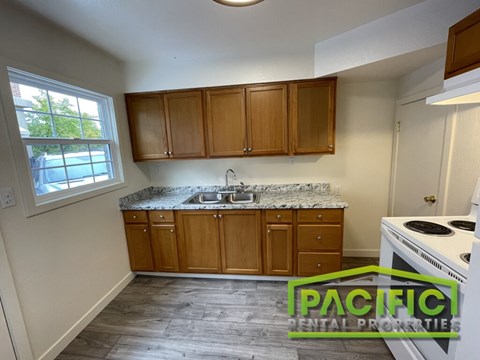 A kitchen with wooden cabinets and a white stove top oven.