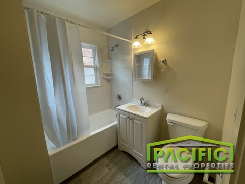 A bathroom with a sink, toilet, and bathtub.